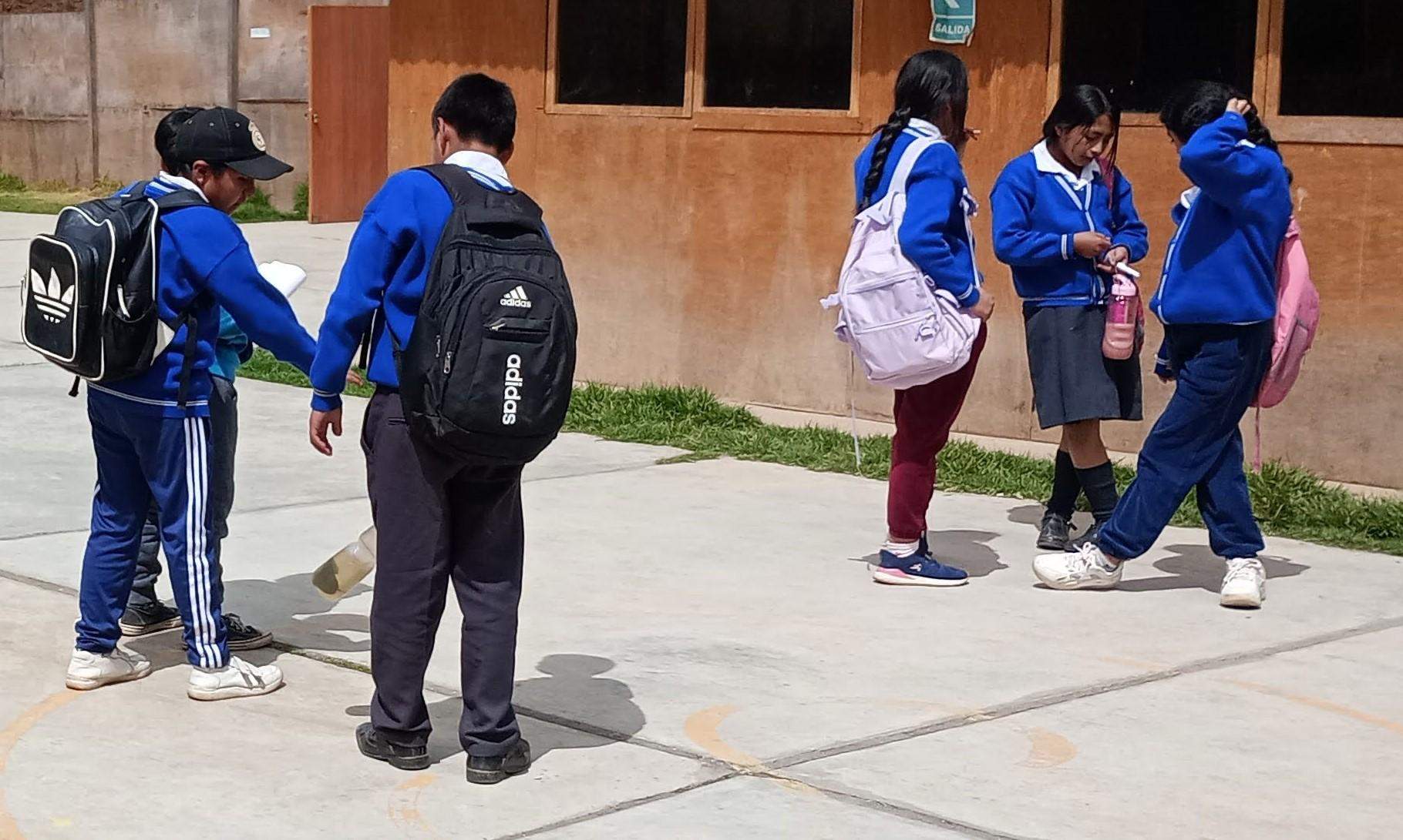 zdjęcie grupki peruwiańskich dzieci w szkolnych mundurkach przed budynkami szkoły
